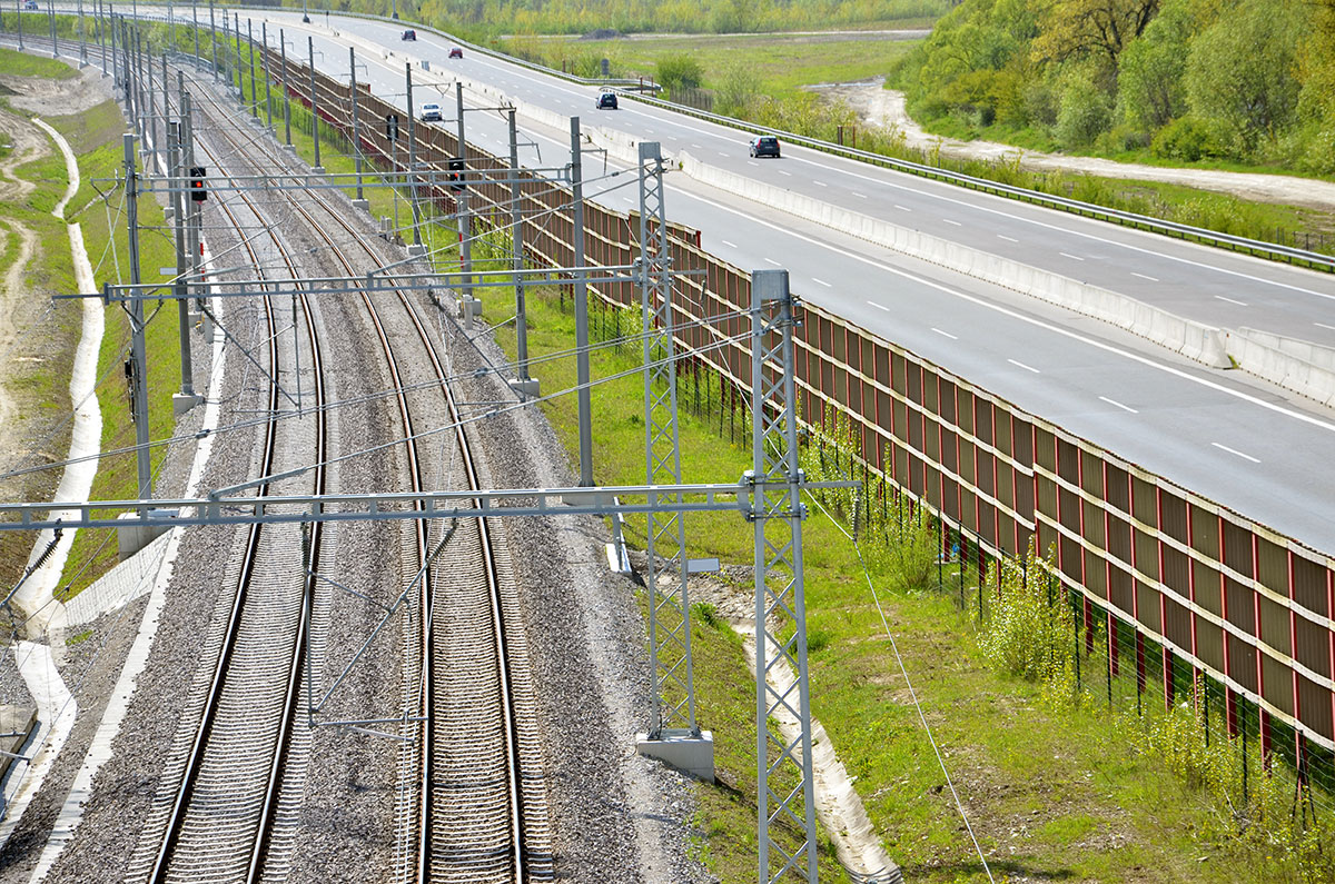 Zwei Gleise neben einer Autobahn