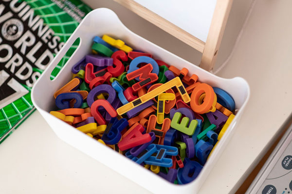 Kiste mit bunten Magnetbuchstaben