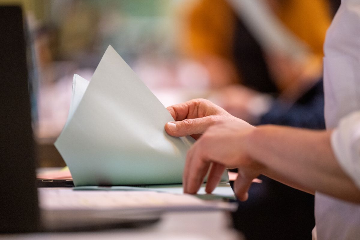 Hände, die durch einen Stoß Papier blättern