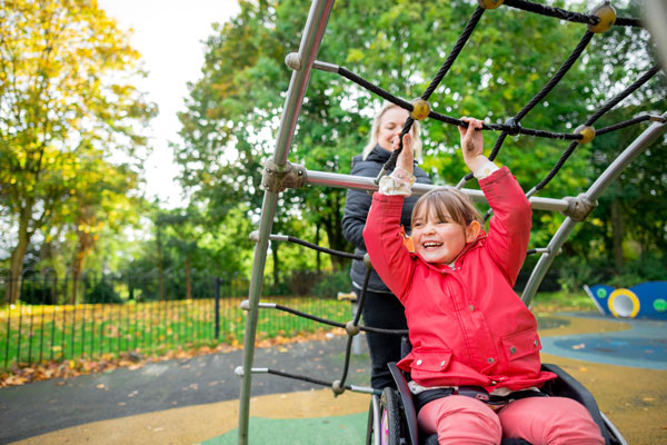 Kind im Rollstuhl auf Spielplatz