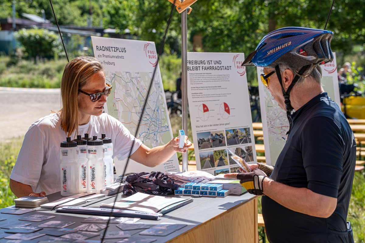 Zwei Personen unterhalten sich an einem Stand zum Thema Fahrradfahren in Freiburg