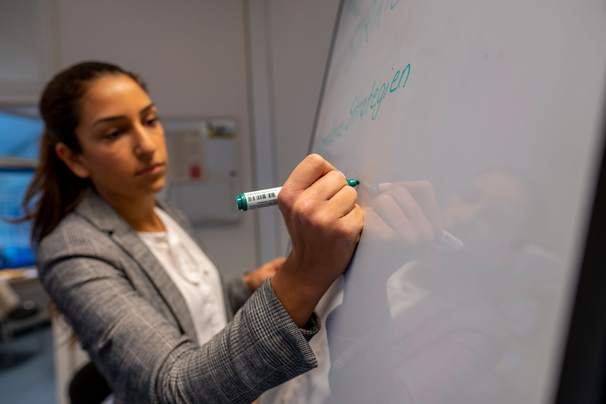 Eine Frau schreibt auf ein Whiteboard