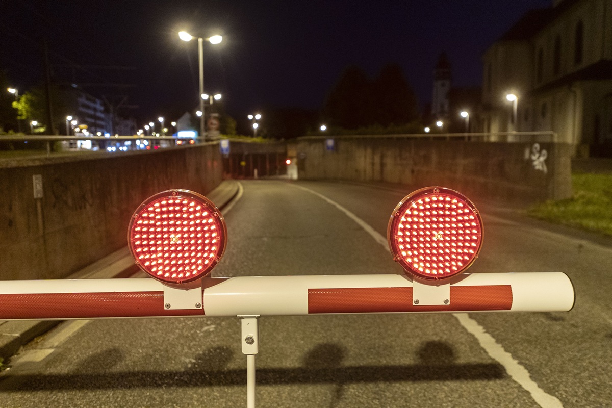 Der Tunneleingang an der B31, davor eine heruntergefahrene Schranke mit zwei roten Leuchten.