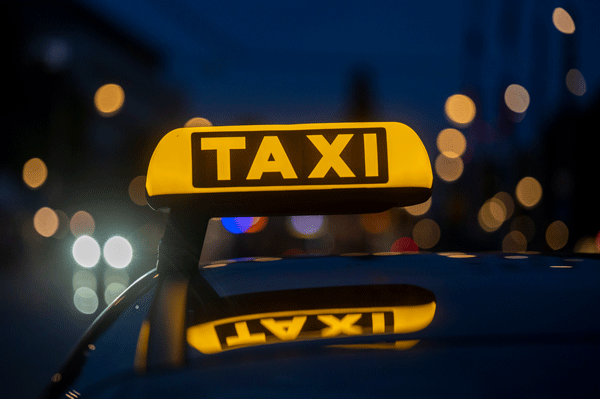 Taxischild auf einem Auto bei Nacht