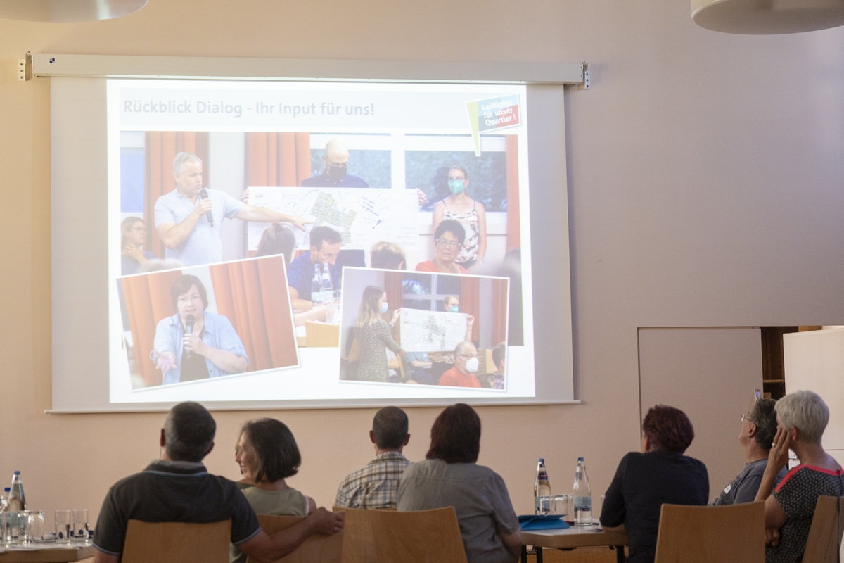 Menschen sitzen vor einer Leinwand