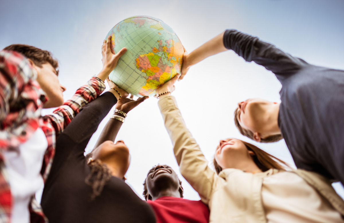 Mehrere Menschen halten einen Globus