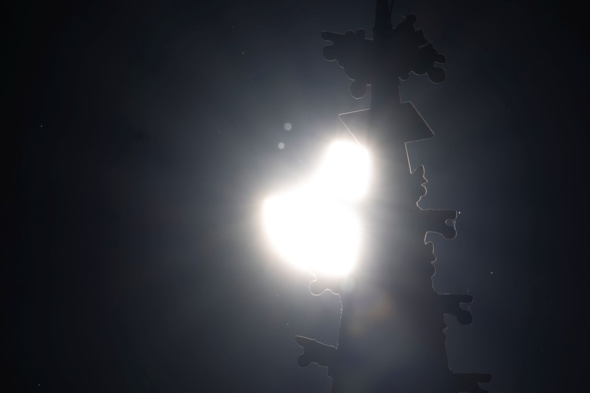Eine partielle Sonnenfinsternis scheint durch den Münsterturm