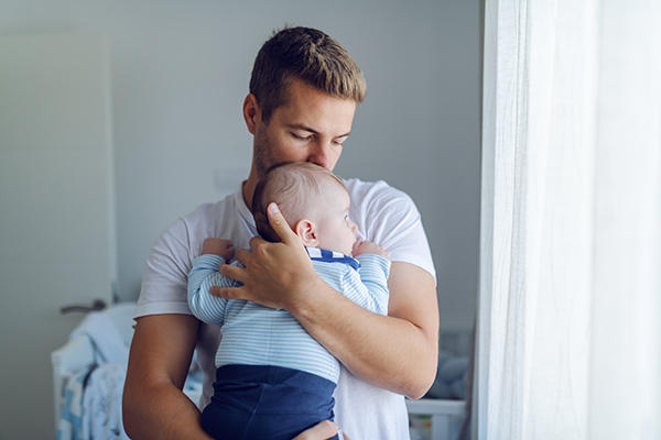 Mann mit Baby auf dem Arm
