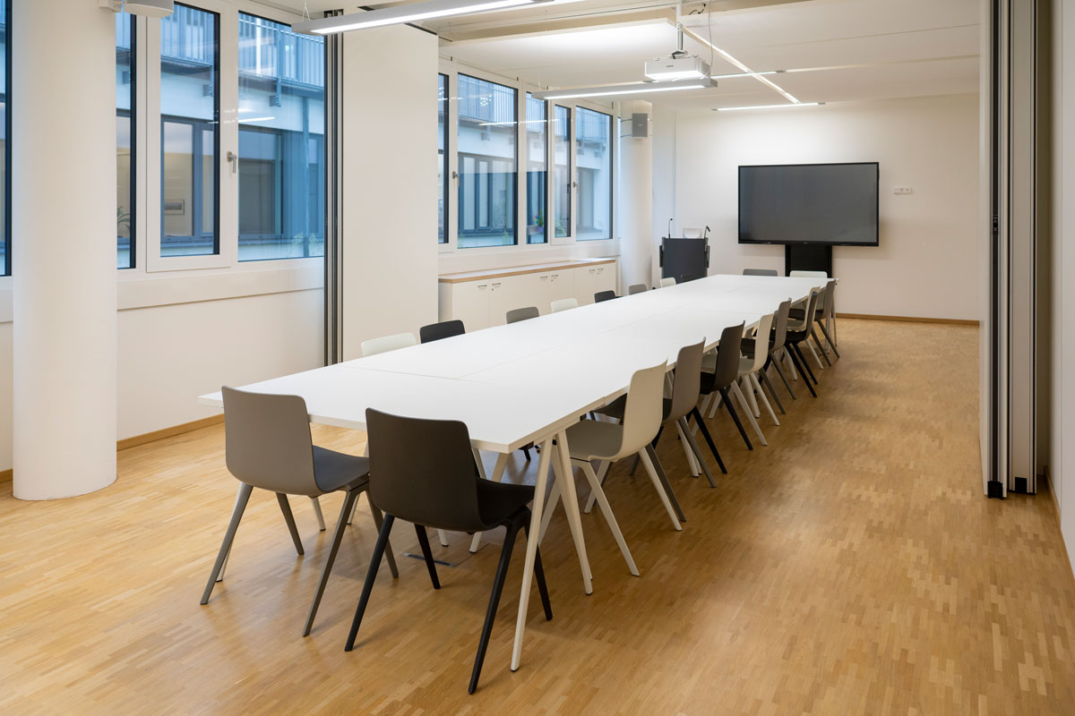 Konferenzraum mit großem Bildschirm an der Wand