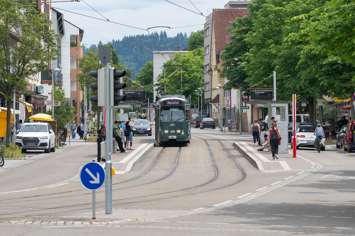 Straßenverlauf der Carl-Kistner-Straße mit Straßenbahn, Menschen, Autos