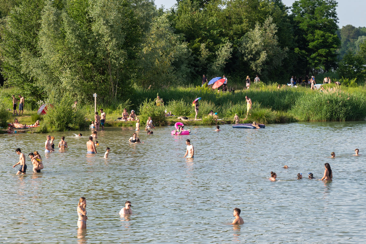 Viele badende Menschen in einem Baggersee