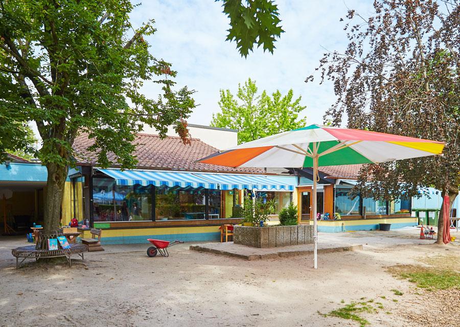 Garten der Kita Regenbogen mit großem Sonneschirm