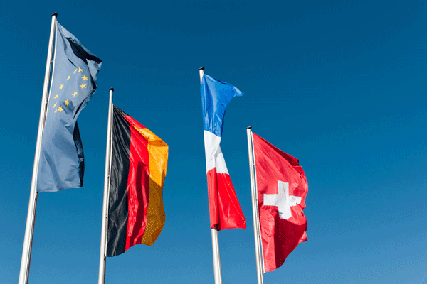 Europaflagge neben deutscher, französischer und schweitezr Fahne vor blauem Himmeö