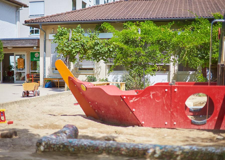 Sandkasten der Kita Piratenbucht mit einm Holzschiff