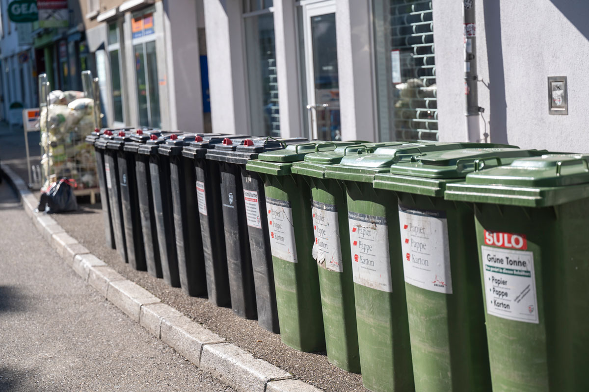 Viele aneinander gestellte Mülltonnen und Gelbe Säcke