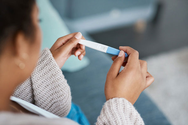Foto: PeopleImages/istockphoto.com Frau hält Schwnagerschaftstest