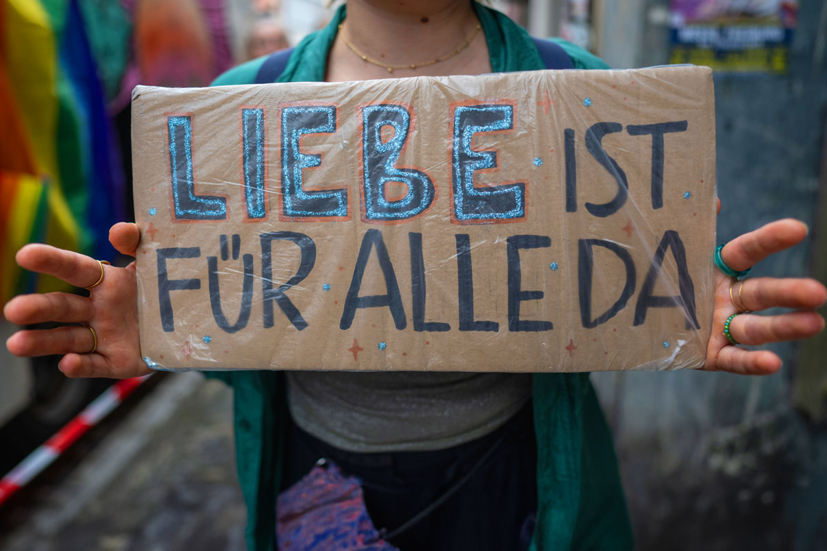Pappschild mit der Aufschrift "Liebe ist für alle da"