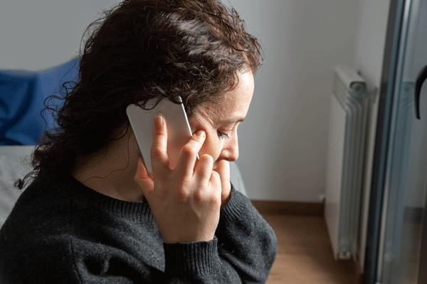 Frau hält Handy ans Ohr und telefoniert